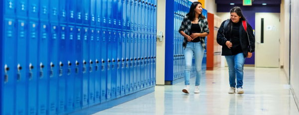 students walking past lockers in a high school hallway (c) Getty Images